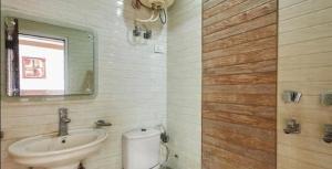 a bathroom with a sink and a toilet and a mirror at Hotel Indo Continental in New Delhi