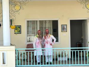 two men standing on the balcony of a house at Dá Bungalow - A Vacation Abode in Agra