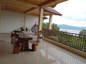 a patio with wooden tables and a balcony at Alice Villa in Tuktuk Siadong