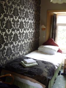 a bedroom with a bed with a black and white wallpaper at Meadowbank in Ambleside