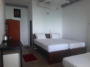 1 Schlafzimmer mit 2 Betten, einem Schreibtisch und einem Bett in der Unterkunft SEASHORE Resort & Villa in Talpe