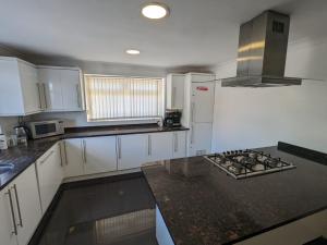 a kitchen with white cabinets and a stove top oven at OYO Ormsby Townhouse in Middlesbrough