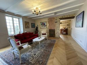 ein Wohnzimmer mit einem roten Sofa und einem Kamin in der Unterkunft Chateau La Rametiere in Plomb