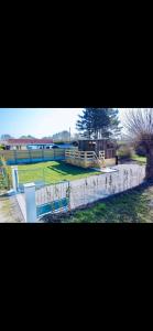 un parc avec une clôture et un champ d'herbe dans l'établissement La Tiny house, à Ardres