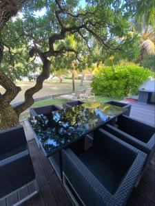 stół i krzesła siedzące pod drzewem w obiekcie Villa No2 - Sun Tan Palmar w mieście Belle Mare