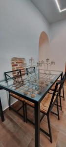 a glass table in a room with two chairs at Apartamento BAÑOS ÁRABES DEL CENIZAL antes Plaza de las Fuentes in Toledo +18 photos