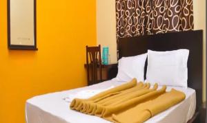 a bed with a yellow and black headboard at FabExpress Century Gardens in Bangalore