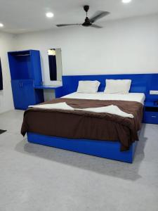 a bedroom with a blue bed with a brown blanket at HOTEL NEW RATNAKAR in Daman