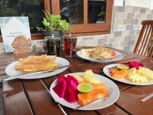 três pratos de comida numa mesa de madeira em Nan Bungalows Tetebatu em Tetebatu