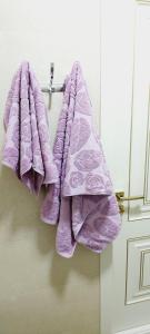 a group of purple towels hanging on a door at Comfortable apartment in Tashkent in Yunusobod