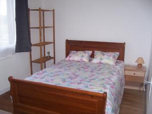 een slaapkamer met een bed met een houten frame bij Calme et tranquillité in Selles-Saint-Denis