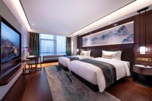 Posteľ alebo postele v izbe v ubytovaní New Century Hotel Qianchao Hangzhou