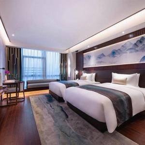 Posteľ alebo postele v izbe v ubytovaní New Century Hotel Qianchao Hangzhou
