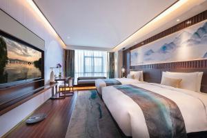 Posteľ alebo postele v izbe v ubytovaní New Century Hotel Qianchao Hangzhou