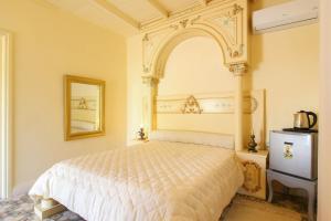 um quarto com uma cama branca e um arco por cima. em Gîte Feki em Sfax