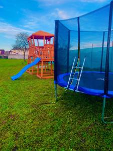 two playground equipment in a field with a blue tarp at Tacchini's Home in Plosca