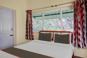 a bedroom with a bed and a window with curtains at STARLIGHT HOTELS KODAI in Kodaikānāl