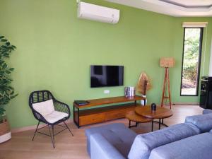 a living room with a couch and a tv at The Happinezz Hills Hotel in Karimunjawa