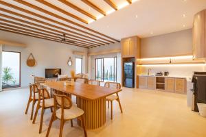 a kitchen and dining room with a wooden table and chairs at The Clara Ville in Canggu