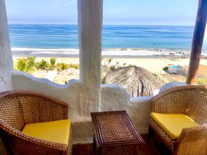 a room with two chairs and a view of the beach at Hotel Smiling Crab in Canoas de Punta Sal