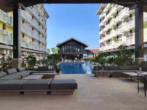 a courtyard with couches and a pool in a building at Anya and Carl's Comfy in Mactan