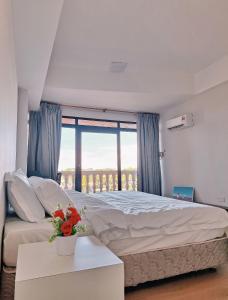 a bedroom with a large bed and a large window at Cozzzy hut Riverbank Suites Kuching with spectacular River view in Kuching