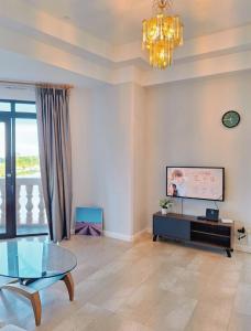 een woonkamer met een glazen tafel en een kroonluchter bij Cozzzy hut Riverbank Suites Kuching with spectacular River view in Kuching