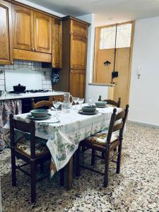 cocina con mesa con sillas y mantel en Casadelborgo en Bassiano
