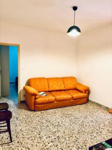 um sofá laranja sentado numa sala de estar em Casadelborgo em Bassiano