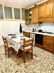 uma cozinha com uma mesa com 2 cadeiras e um fogão em Casadelborgo em Bassiano