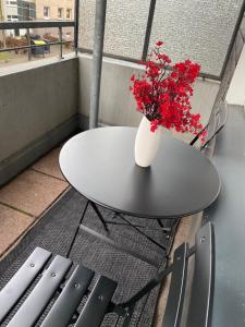 a table and chairs with a vase with red flowers at Gemütliches Zuhause in 1A Lage in Herne