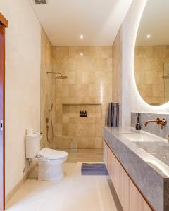 La salle de bains est pourvue de toilettes, d'un lavabo et d'une douche. dans l'établissement The Clara Ville, à Canggu
