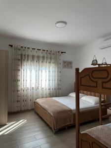 a bedroom with a bed and a window with curtains at Davide's guesthouse in Vlorë