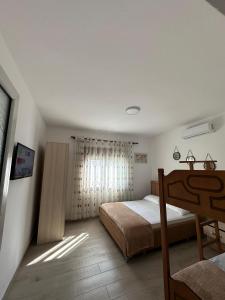 Habitación pequeña con cama y ventana en Davide's guesthouse en Vlorë