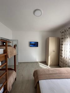 a bedroom with two bunk beds and a wooden cabinet at Davide's guesthouse in Vlorë
