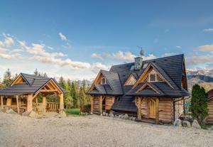 a large log cabin with a black roof at Domki Tatra Lux Zakopane in Kościelisko