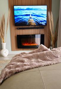 a living room with a fireplace with a tv above it at Adante @ Midrand in Midrand