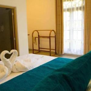 - une chambre avec un lit recouvert de cygnes dans l'établissement ROCK VIEW RELAX Inn, à Sigirîya
