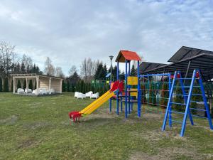 a playground with a yellow and blue slide and a slideintend at Apartamenty Baltic in Karwia