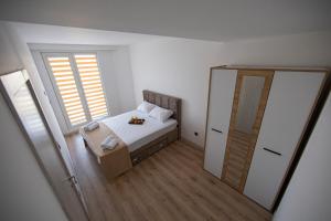 um pequeno quarto com uma cama e um espelho em CEVAHIR SKY CITY Skopje JK Apartments em Skopje