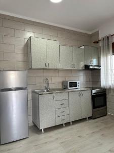 una cucina con frigorifero in acciaio inox e forno a microonde di Davide's guesthouse a Vlorë