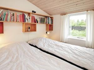 um quarto com uma cama e uma janela com livros em Holiday Home Foldenvej em Jerup
