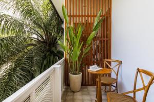 a balcony with plants and a table and chairs at White Goose Boutique Hotel in Canggu