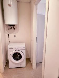 a washer and dryer in a small room at Apartment Mare45 - 10 minutes walk from the beach with one private ombrella and three sun-beds in Eraclea Mare +5 photos