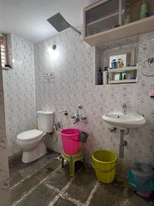 a bathroom with a toilet and a sink with buckets at 2BHK with parking & ample space in Bangalore