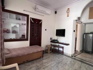 a room with a bed and a television in it at 2BHK with parking & ample space in Bangalore