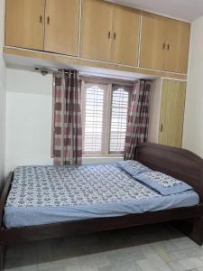 a bedroom with a bed and a window at 2BHK with parking & ample space in Bangalore