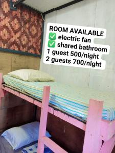 a pink bunk bed in a room with a sign at sharkbunkbed siargao in General Luna