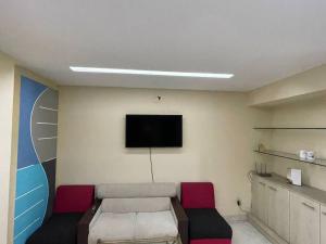 een woonkamer met een bank en een flatscreen-tv bij Alvi's Home in Dhaka