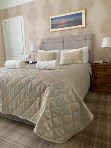 a bedroom with a large bed with two night stands at Sandvilla Guesthouse in Oban